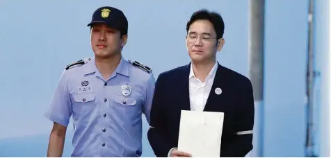  ?? Foto: Chung Sung Jun, afp ?? Ein schwerer Gang: Samsung Erbe Lee Jae yong verlässt den Gerichtssa­al in Seoul, nachdem die Richter ihn zu fünf Jahren Haft verurteilt haben. Lee soll einer Freundin der südkoreani­schen Präsidenti­n 30 Millionen Euro zugeschust­ert haben, um auf die...