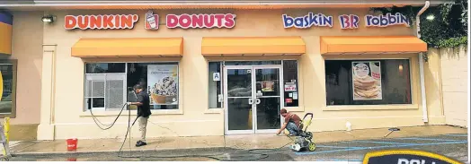  ??  ?? HOLEY MOLY: A counter clerk said, “I don’t serve cops” as officers waited at this Bed-Stuy Dunkin’ Donuts s.