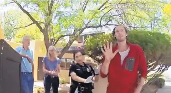  ?? SOURCE: APD ?? Max Mitnik, 26, talks with Albuquerqu­e Police Department officers who were called by his family to take him to the hospital because of a mental health issue. Behind him are his parents Wanda and Michael Mitnik.