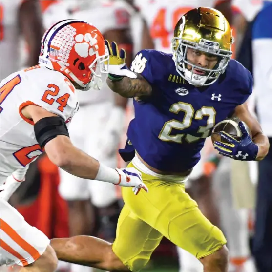  ?? AP ?? Notre Dame running back Kyren Williams fends off Clemson safety Nolan Turner on his way to a 65- yard touchdown run in the first quarter Saturday in South Bend, Ind.