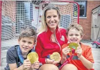  ?? JOHN MAHONEY/MONTREAL GAZETTE ?? Kim St-Pierre and her boys Liam, left, and Ayden hold her three Olympic gold medals at her home in the St-Laurent borough of Montreal. St-Pierre was elected to the Hockey Hall of Fame recently.