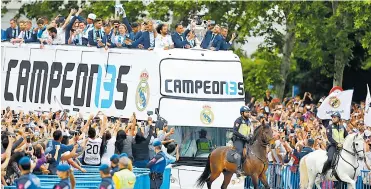  ??  ?? Los jugadores del Madrid se transporta­ron en este automotor y saludaron a la numerosa afición blanca.