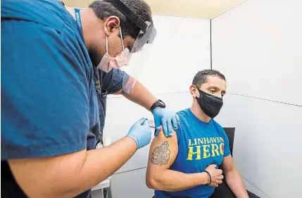  ?? JULIE JOCSAK TORSTAR ?? Dr. Karim Ali of Niagara Health administer­s the COVID-19 vaccine for the first time in Niagara to Faber Baquero, a personal support worker at Linhaven Nursing Home, at the St. Catharines hospital site on Wednesday.