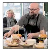  ??  ?? Tino Belasco serves sandwiches at Natural State Sandwiches in Springdale, a business that began as a food truck.