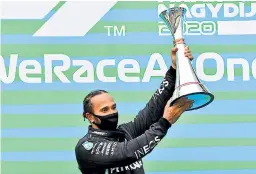  ??  ?? CONQUISTA. Hamilton levanta con orgullo el trofeo en Budapest.