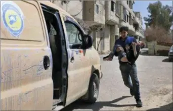  ?? SYRIAN CIVIL DEFENSE WHITE HELMETS VIA AP ?? This photo released by the Syrian Civil Defense White Helmets, shows a member of the Syrian Civil Defense group carrying a boy who was wounded during airstrikes and shelling by Syrian government forces in Ghouta, a suburb of Damascus, Syria, Sunday.