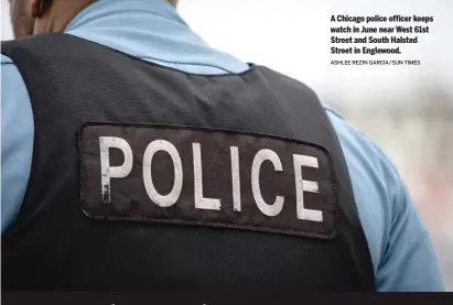  ?? ASHLEE REZIN GARCIA/SUN-TIMES ?? A Chicago police officer keeps watch in June near West 61st Street and South Halsted Street in Englewood.