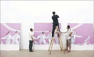  ?? Photograph­s by Adam Sjoberg ?? SUN MU’S PAINTINGS go up at the Yuan Art Museum in Beijing last year. Authoritie­s later pressured the organizers to cancel the solo exhibition. The ordeal is covered in the documentar­y “I Am Sun Mu.”