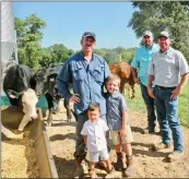  ??  ?? Lucas Moore, center, is joined by his sons, Joe Hank, 3, and Cotton, 6, in feeding the cattle as Lucas’ brothers, Nicholas, back, and Joshua, far right, watch. The three brothers raise cattle, as well as soybeans, wheat and corn.