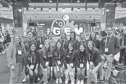  ?? PROVIDED BY CATHERINE XIE ?? Team RoSynth, from the University of Rochester, posing by the iGEM sign at the 2023 Grand Jamboree in Paris, France.