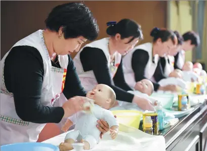  ?? LI YAFENG / FOR CHINA DAILY ?? Maternity nurses participat­e in a baby care competitio­n in Qinyang, Henan province, in April last year.