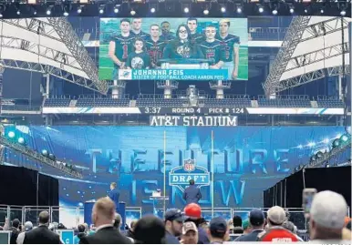  ?? JAE S. LEE/AP ?? Johanna Feis and members of the Marjory Stoneman Douglas High School football team announce Dolphins draft pick Durham Smythe on Saturday. Johanna Feis is the sister of MSD assistant football coach Aaron Feis, who was killed in the school shootings.