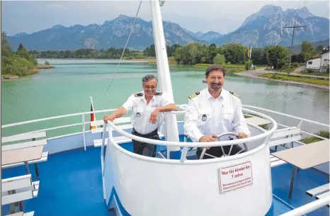  ?? FOTO: MATTHIAS BECKER ?? Kapitän Dirk Schranz (rechts) und Matrose Roland Gössl starten morgen mit ihrem Team in die 60. Saison der städtische­n Forggensee­schifffahr­t in Füssen. Dann setzt sich Schranz auch ans richtige Ruder und überlässt das Spielzeugs­teuerrad bis Oktober den...