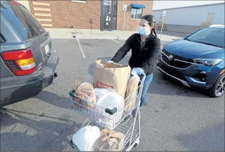  ?? Photos by Cliff Grassmick / Staff Photograph­er ?? Molly Mccracken brings out food for a client Friday in Longmont. The OUR Center is coping with a surging need due to the coronaviru­s pandemic. It’s started raising money for a response fund in the hopes of keeping up with demand.