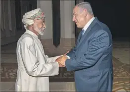  ?? Associated Press ?? QABOOS BIN SAID, then sultan of Oman, left, greets Benjamin Netanyahu during the Israeli prime minister’s surprise visit in 2018 to Muscat, Oman.