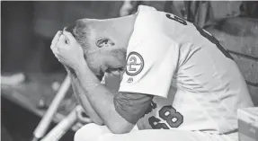  ??  ?? Cardinals pitcher Austin Gomber holds his head in his hands after being pulled against the Braves during the seventh inning on Friday.