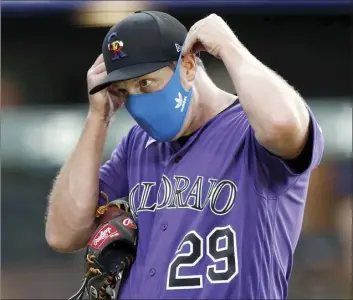  ?? AP photo ?? Colorado Rockies relief pitcher Bryan Shaw puts on his face mask after taking part in drills during the team’s practice at Coors Field on Friday in Denver.