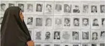  ?? |GETTY ?? Una mujer iraquí mira las fotos de los desapareci­dos durante los años 19802003, durante el régimen de Saddam Hussein.