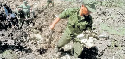  ?? Archivo ?? Un militar uruguayo rescata una pieza del DC9 en el cráter que dejó su caída