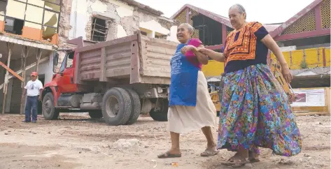  ??  ?? Juchitecos hacen su vida cotidiana entre cascajo e inmuebles dañados y tienen temor de que un nuevo movimiento telúrico afecte a la entidad.