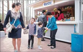  ?? ED JONES /AFP ?? People buy snacks from a vendor at a zoo in Pyongyang on April 16.