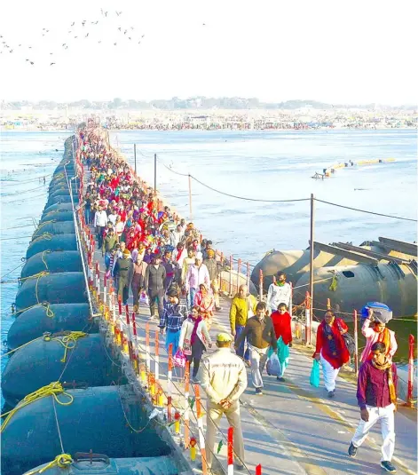  ?? SANJAY KANOJIA/AGENCE FRANCE-PRESSE ?? HINDU devotees cross a pontoon bridge as they arrive to take a holy dip on the eve of ‘Mauni Amavasya’ during the annual religious ‘Magh Mela’ festival on the banks of Sangam, the confluence of rivers Ganga, Yamuna and mythical Saraswati, in Prayagraj, India.