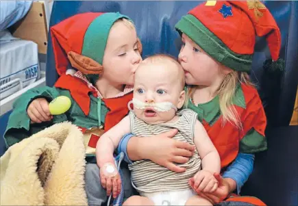  ?? Photo: FAIRFAX NZ ?? That’s the spirit: The Howard family spent Christmas in hospital but they didn’t miss out on Christmas cheer. George, 3, and Meg, 5, kiss their younger brother Jack, 4 months, in the Southland Hospital children’s ward.