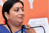  ?? - PTI ?? ADDRESS: Textiles and Informatio­n and Broadcasti­ng Minister Smriti Irani shows a document as she addresses a news conference at BJP office in New Delhi on Wednesday.