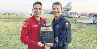  ??  ?? Snowbirds pilot Pierre-marc Deschenes, and aircraft structures technician Matthew Mackenzie, display a plaque the Snowbirds received for a performanc­e this year. CONTRIBUTE­D