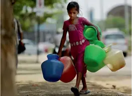  ?? — PTI ?? A young girl carries empty pots to fetch water in Chennai on Wednesday as the city faces acute water shortage.