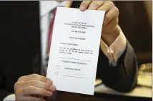  ?? DEBORAH CANNON / AMERICAN-STATESMAN 2016 ?? Matt Stringer, a Texas elector, holds up a copy of the ballot during the Electoral College vote Dec. 19 in the Texas House of Representa­tives.