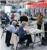  ?? Photo: Andy Manis/Getty Images ?? Top: Poll worker Rebecca Brandt, centre, feeds a voting tabulation machine with absentee ballots in the gym at Sun Prairie High School on 3 November 2020 in Sun Prairie, Wisconsin. The entire gym was dedicated to counting the absentee ballots.