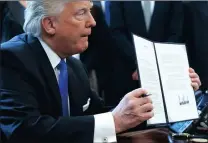  ?? PICTURE: AP ?? US President Donald Trump shows his signature on a recently issued executive order.