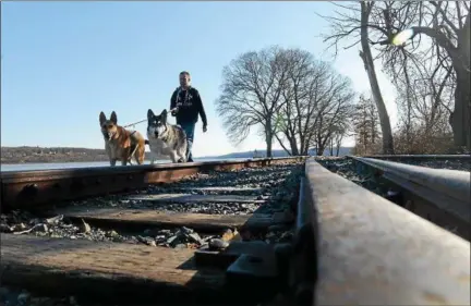  ?? TANIA BARRICKLO—DAILY FREEMAN FILE ?? Tom Biscoglio of Kingston, N.Y. takes his two dogs Riggs, left, and Xena for a walk along the Kingston Rail Trail at Rotary Park in late February.