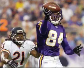  ?? TOM OLMSCHEID — THE ASSOCIATED PRESS FILE ?? Vikings wide receiver Randy Moss pulls in a pass in front of Bears cornerback R.W. McQuarters in the second quarter of 2004 game in Minneapoli­s. Moss, elected to the Pro Football Hall of Fame in his first year of eligibilit­y, ranks second in NFL history with 156 career touchdown receptions and fourth with 15,292 career receiving yards.