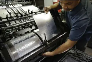  ?? PHOTOS BY STEVEN SENNE, THE ASSOCIATED PRESS ?? Press operator Cham Cha attaches a plate to a printing press at the National Braille Press. The Boston-based organizati­on has been a leading force for Braille literacy in the U.S., since its founding as a weekly newspaper for the blind in 1927. But it...