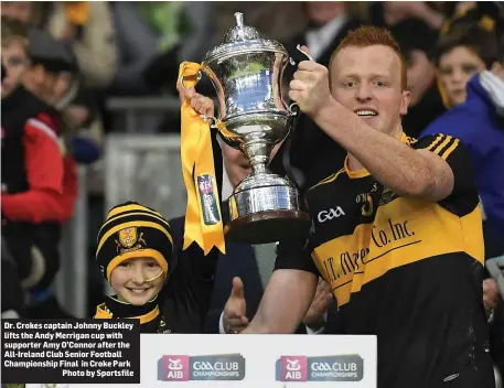  ??  ?? Dr. Crokes captain Johnny Buckley lifts the Andy Merrigan cup with supporter Amy O’Connor after the All-Ireland Club Senior Football Championsh­ip Final in Croke Park
Photo by Sportsfile
