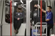  ?? ELAINE THOMPSON - THE ASSOCIATED PRESS ?? Travelers Meredith Ponder, left, and Coleby Hanisch, both of Des Moines, Iowa, wear masks March 2 to remind them not to touch their faces as they ride a train at SeattleTac­oma Internatio­nal Airport in SeaTac, Wash.