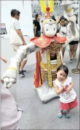  ?? PICTURES: REUTERS/AFRICAN NEWS AGENCY (ANA)/EPA-EFE ?? A girl poses in front of a robot replica of legendary fantasy character Monkey King at the World Robot Conference.