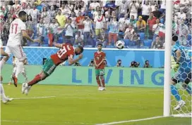  ?? THEMBA HADEBE/ASSOCIATED PRESS ?? Morocco’s Aziz Bouhaddouz (20) accidently knocks in an own goal during the Group B match between Morocco and Iran to help send Iran to its first World Cup victory, 1-0, in St. Petersburg Stadium in St. Petersburg, Russia, on Friday.