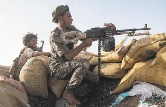  ?? Nariman El-Mofty / Associated Press ?? Hassan Saleh (left) identifies a target for a government fighter during clashes with Houthi rebels on the Kassara front line in Yemen’s long civil war near the city of Marib.