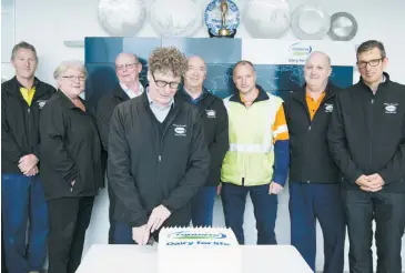  ??  ?? Stuart Martin ciuts the 20-year celebratio­n cake watched by staff who began at the plant 20 years ago (from left): Paul Matthews, Val Davies, Richard Willis, Glen Hayes, Gerard Agnoleto, Richard Godsil and Brendan Miller.