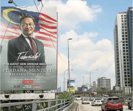  ?? — azman Ghani/the Star ?? Big news: motorists on Jalan bangsar drive by a billboard congratula­ting anwar on his appointmen­t as Prime minister.