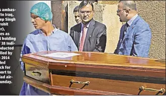  ??  ?? India’s ambassador to Iraq, Pradeep Singh Rajpurohit (center), watches as casket holding one of 38 Indians abducted and killed by ISIS in 2014 is loaded on truck for transport to Baghdad airport Sunday.