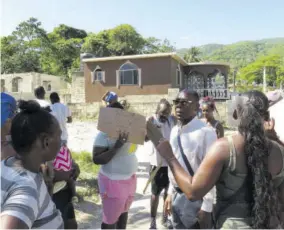  ?? ?? Councillor Michael Troupe speaking to the residents of Meadowsval­e during the protest on Tuesday morning.