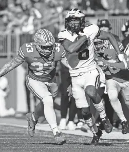  ?? JAY LAPRETE/AP ?? Michigan receiver Cornelius Johnson outruns Ohio State defenders to score a touchdown on Saturday in Columbus, Ohio.