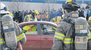  ?? JOE GIBBONS/THE TELEGRAM ?? Firefighte­rs tend to a mock accident victim, portrayed by student actor Elizabeth Johnson, as she was placed in a neck brace for immobiliza­tion to prevent further “injury” as the vehicle door was being extricated using the Jaws of Life.