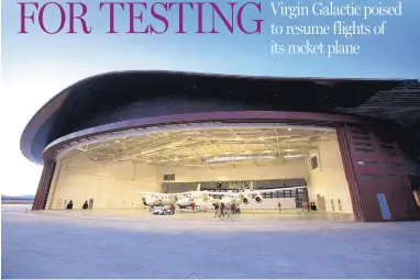  ?? COURTESY OF VIRGIN GALACTIC ?? Virgin Galactic’s SpaceShipT­wo, attached to mother ship White-Knight-Two, is shown at Spaceport America in New Mexico before the spaceship crashed in 2014. The company is now ready to resume powered test flights, with the goal of launching full...