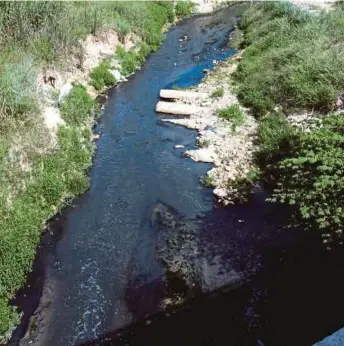  ??  ?? Air Sungai Kim Kim di Pasir Gudang berwarna kehitaman akibat pencemaran sisa toksik.