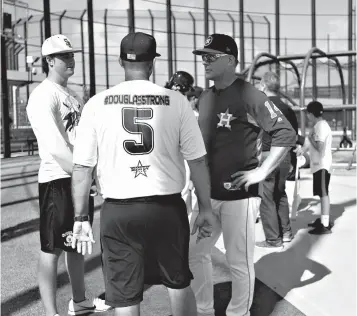  ?? Associated Press ?? ■ Houston Astros manager A.J. Hinch talks with Douglas Stoneman High School's baseball head coach Todd FitzGerald, center, and his son, Hunter Fitz-Gerald, left, during baseball spring training Friday in West Palm Beach, Fla.